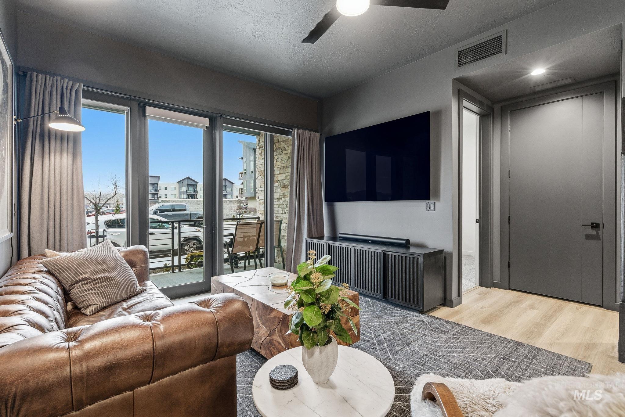 3928 East Haystack Street, Unit 107 Boise, ID 83716 - Photo 9 of 37 Living area featuring a ceiling fan, wood finished floors, and a textured ceiling