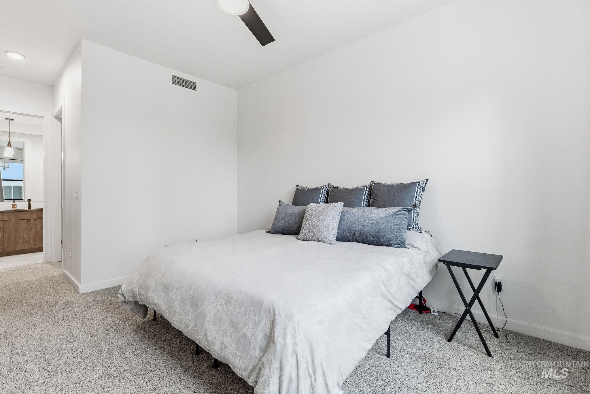 3928 East Haystack Street, Unit 107 Boise, ID 83716 - Photo 11 of 37 Bedroom featuring carpet floors, a ceiling fan, and connected bathroom