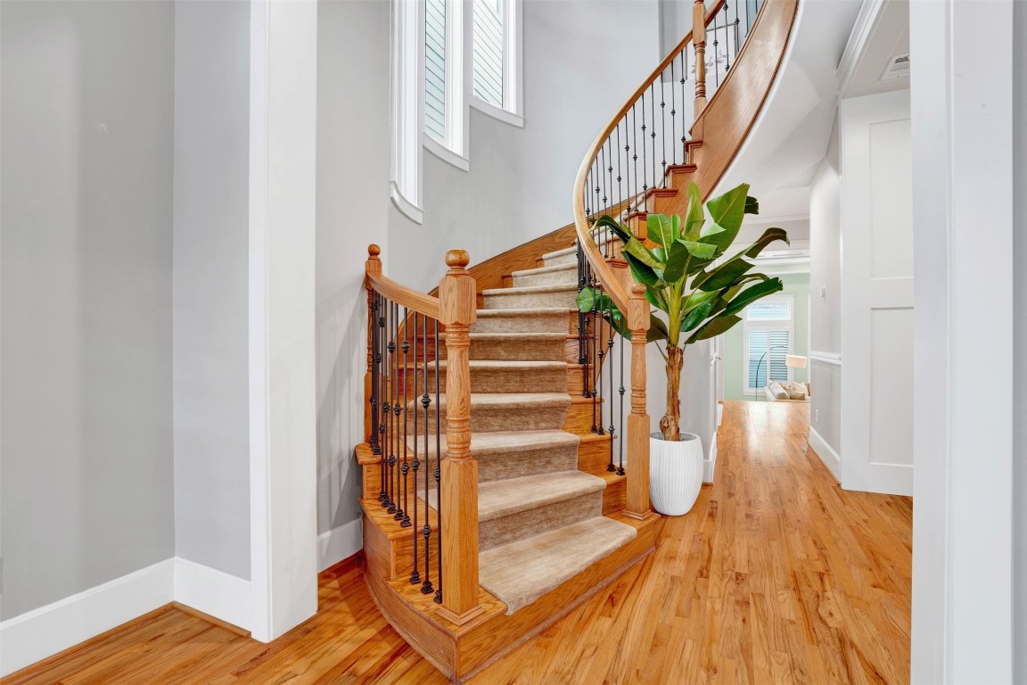 612 Rutland Street Houston, TX 77007 - Photo 24 of 45 Artistry in Every Step. The sweep of the curved staircase showcases the meticulous craftsmanship found on every level. This view captures the heart of the home’s vertical volume, connecting the social living spaces to the quiet luxury of the upper bedrooms.
