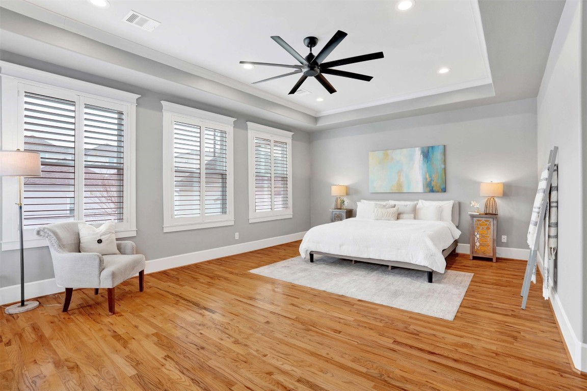 612 Rutland Street Houston, TX 77007 - Photo 34 of 45 Grand Primary Suite. The expansive primary suite is a masterclass in serene design. Featuring soaring tray ceilings and pristine hardwood floors, this sun-drenched sanctuary offers plenty of room for a king-sized suite and a private sitting area.