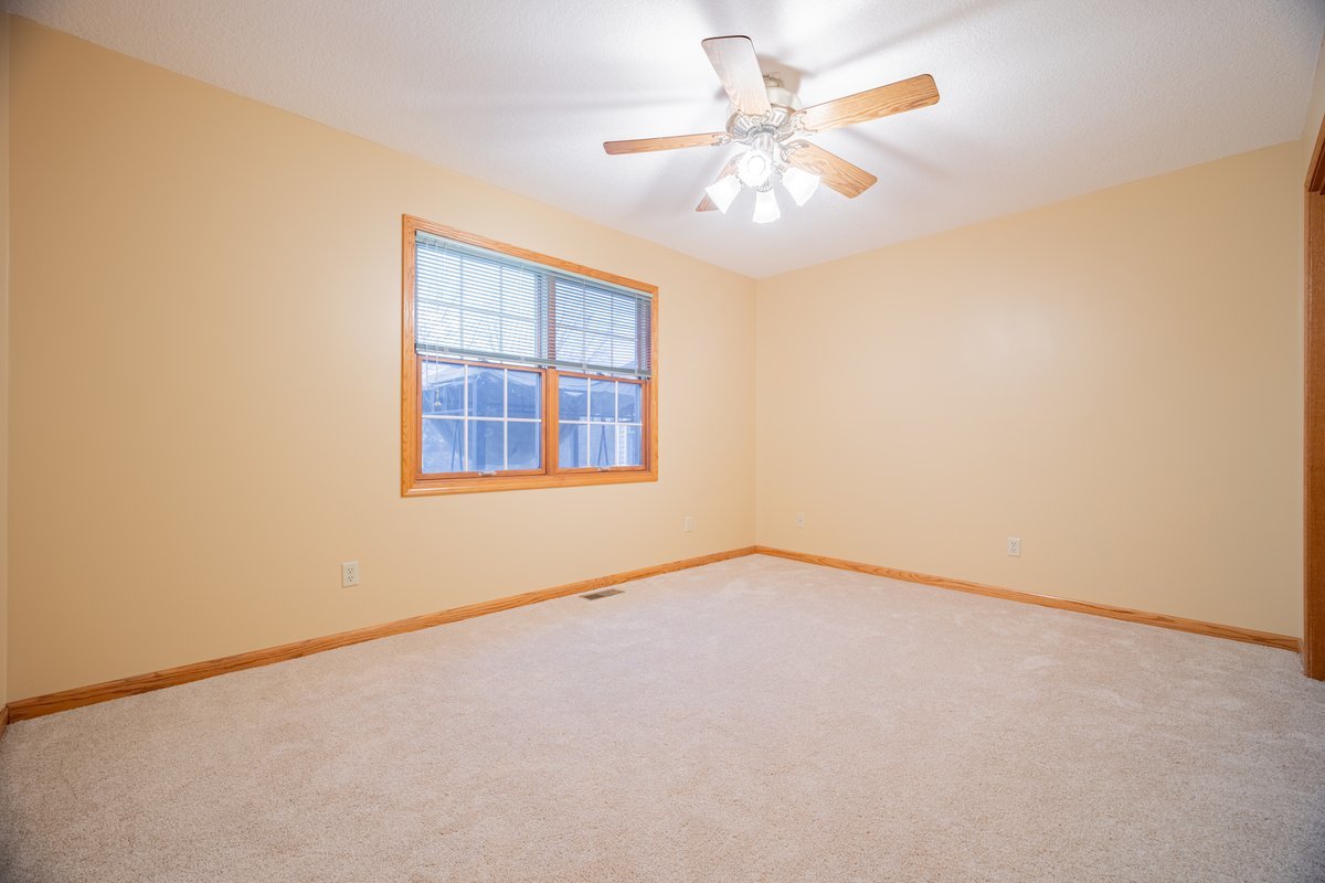 8401 Idlewood Road Clinton, IL 61727 - Photo 16 of 42 an empty room with a chandelier fan and windows