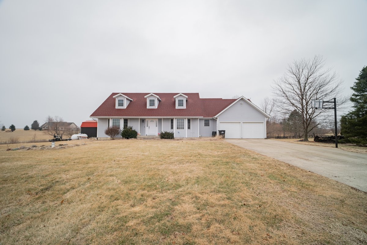 8401 Idlewood Road Clinton, IL 61727 - Photo 4 of 42 a front view of house with yard and trees in the background