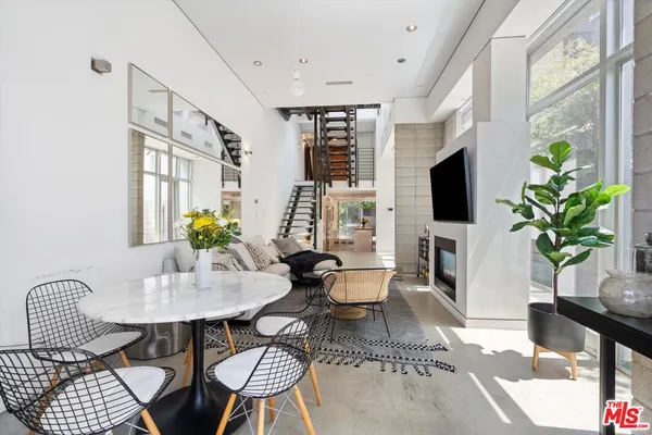 a living room with furniture a flat screen tv and a potted plant