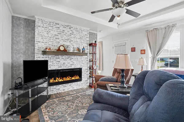 a living room with furniture a flat screen tv and a fireplace