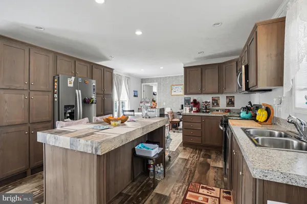 a kitchen with granite countertop a sink stove and refrigerator