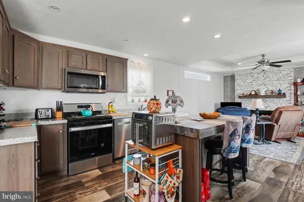 a kitchen with stainless steel appliances granite countertop a stove top oven a sink dishwasher and cabinets with wooden floor