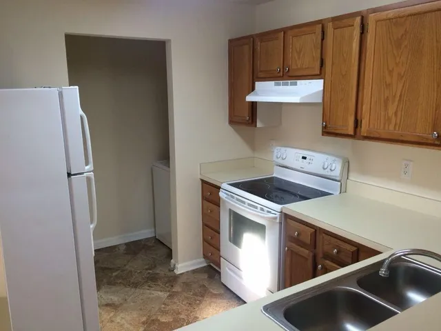 a kitchen with a refrigerator sink and cabinets