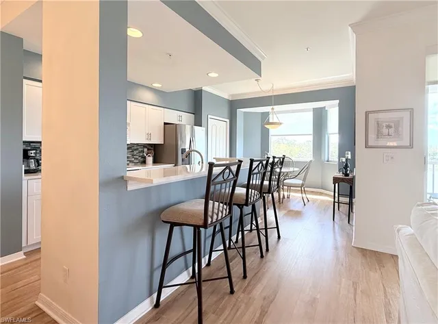 a view of a a dining room with furniture window and wooden floor