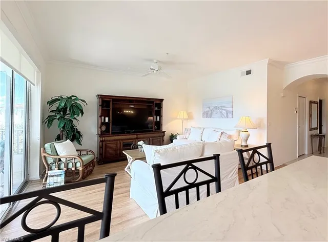 a living room with furniture a flat screen tv and a potted plant