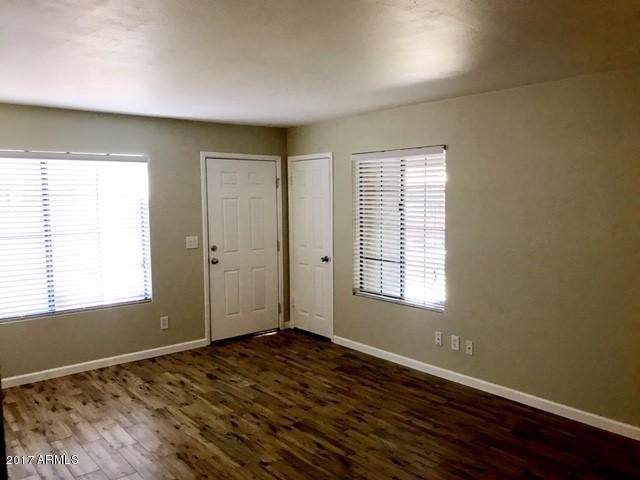 700 East Mesquite Circle, Unit N127 Tempe, AZ 85288 - Photo 4 of 16 a view of an empty room with wooden floor and a window