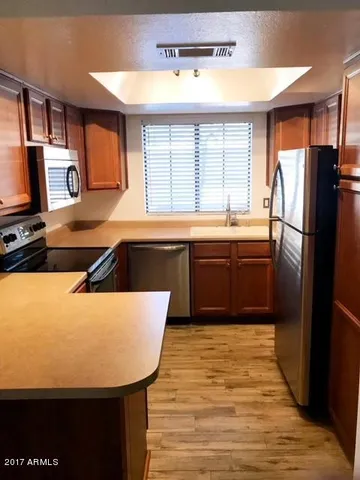 a kitchen with stainless steel appliances granite countertop a sink a stove and refrigerator