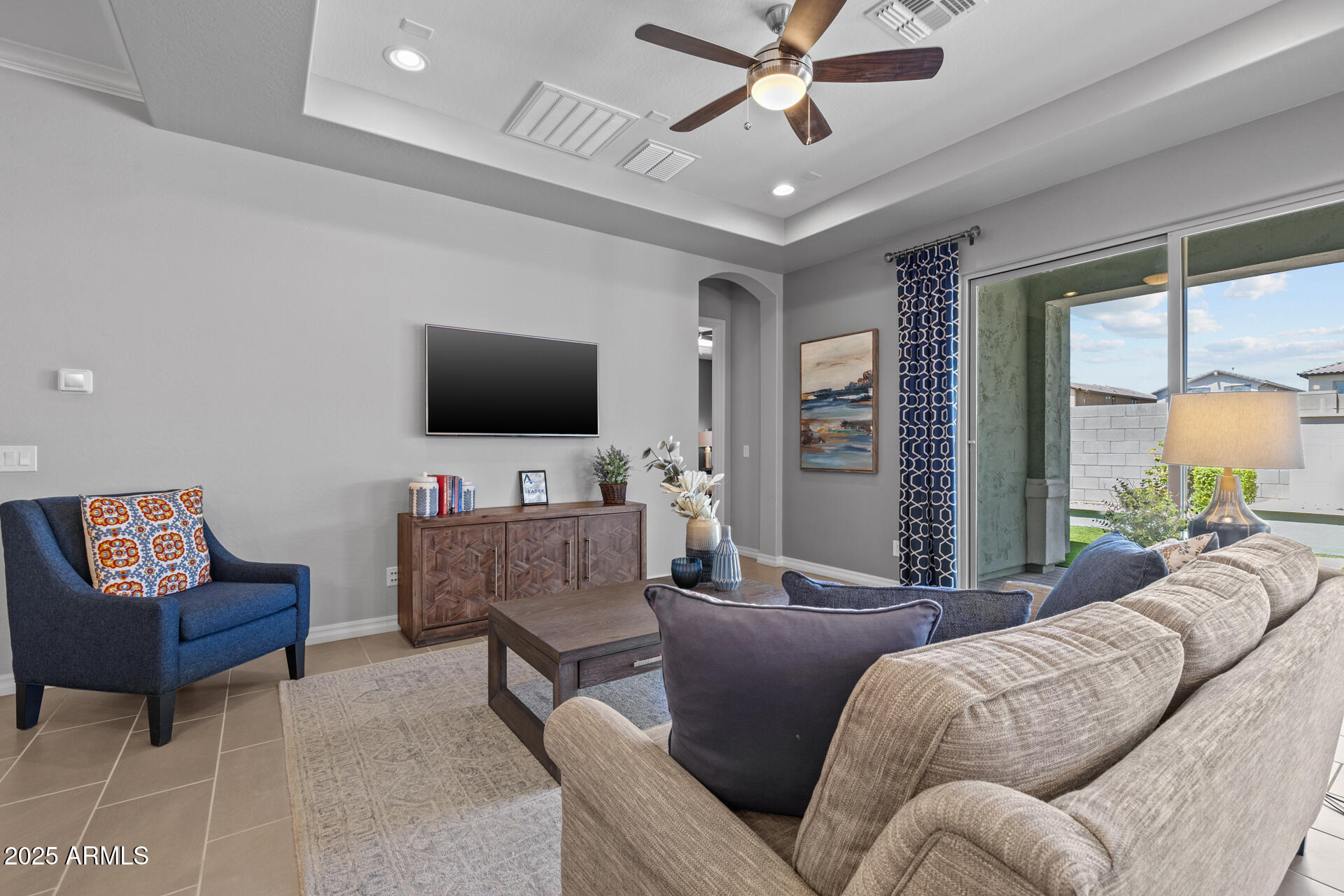4273 East John Street Gilbert, AZ 85295 - Photo 7 of 29 a living room with furniture a ceiling fan and a flat screen tv