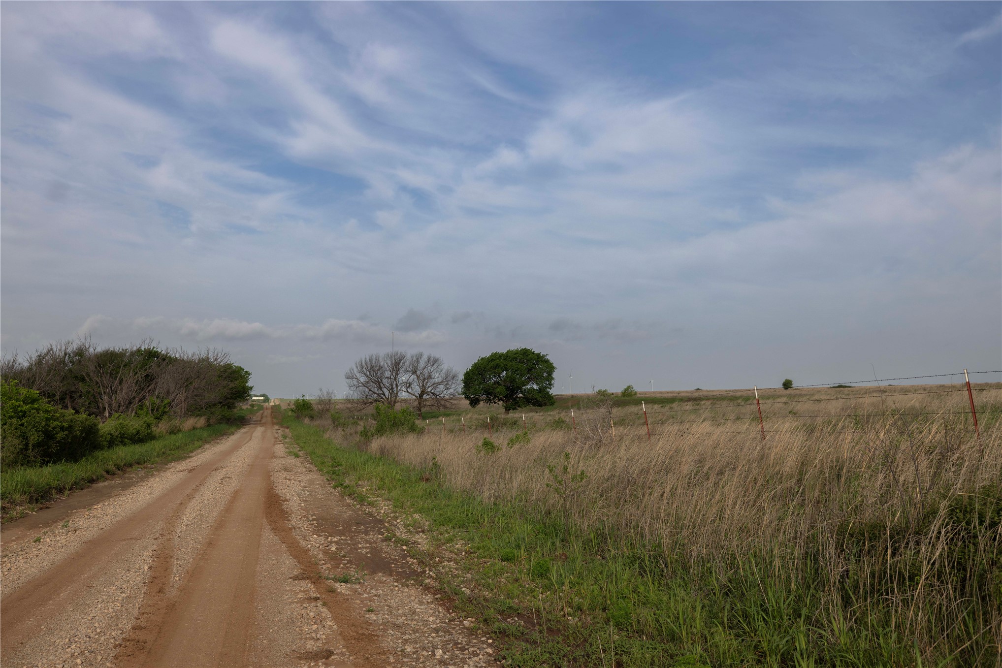 42 East 4500 Road Morrison, OK 73061 - Photo 5 of 37 Expansive rural acreage featuring a private dirt access road, native grassland, and scattered mature trees across open terrain