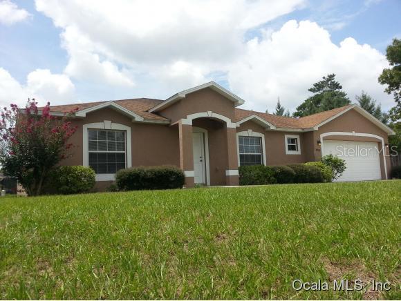 4902 Southwest 115th Street Road Ocala, FL 34476 - Photo 1 of 1 a front view of a house with a yard and garage