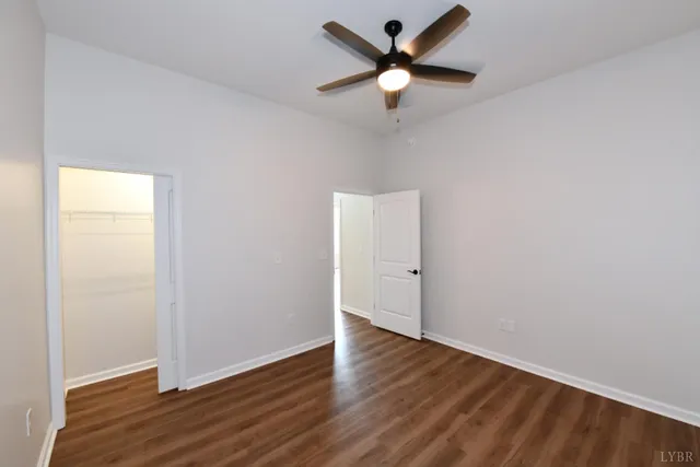 an empty room with wooden floor a ceiling fan and closet