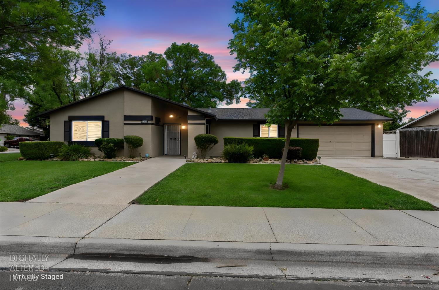 a front view of a house with garage and plants