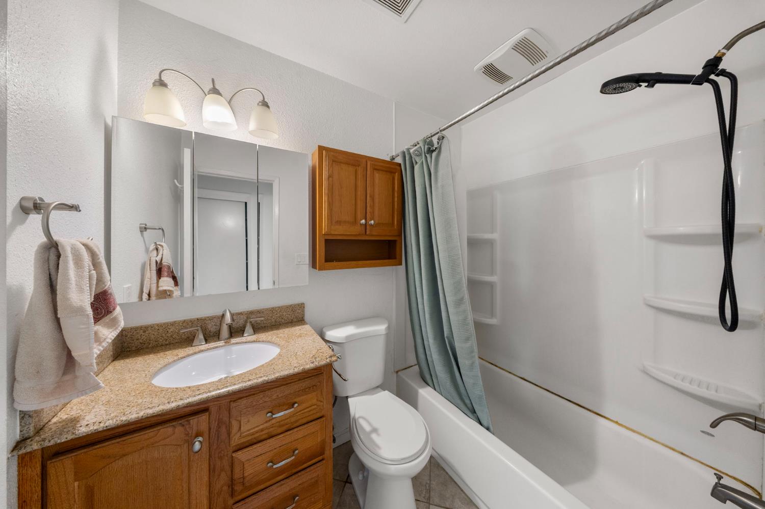 1120 Shasta Avenue Modesto, CA 95358 - Photo 27 of 35 a bathroom with a granite countertop sink toilet and shower