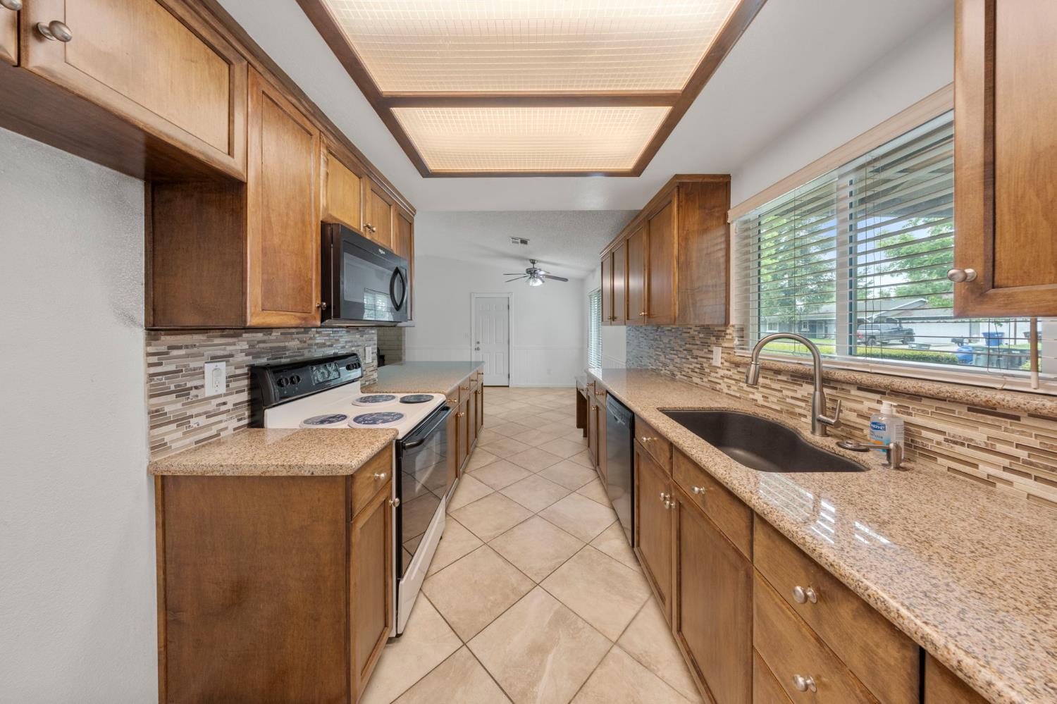 1120 Shasta Avenue Modesto, CA 95358 - Photo 6 of 35 a kitchen with stainless steel appliances granite countertop a sink and a stove
