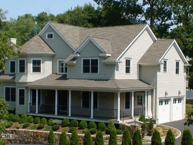 12 Adley Road Fairfield, CT 06825 - Photo 1 of 1 a view of a white house with large windows and a small yard