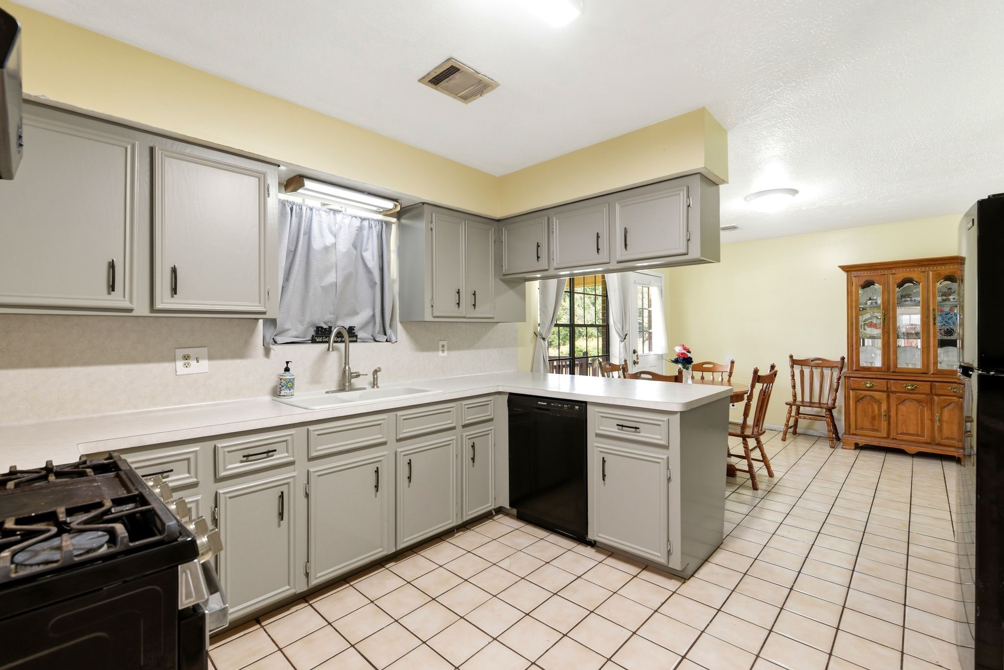 151 Parker Road New Waverly, TX 77358 - Photo 12 of 36 Charming kitchen with sleek gray cabinetry, ample counter space, and a cozy dining area that invites natural light.