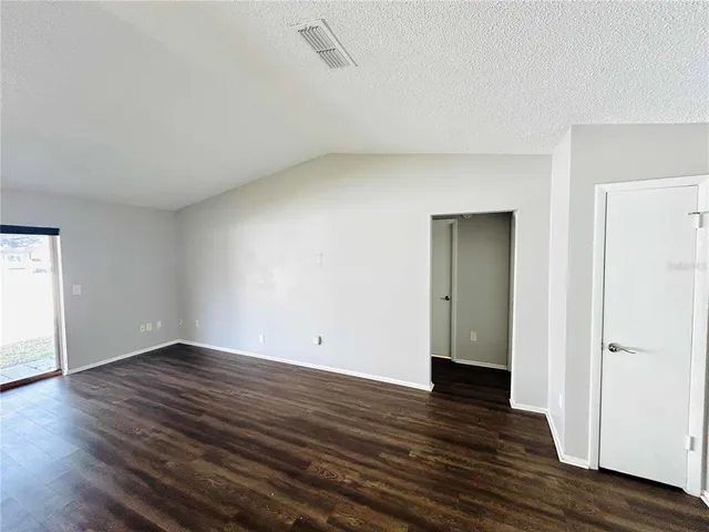 a kitchen with stainless steel appliances granite countertop a sink a stove a refrigerator with white cabinets and wooden floor