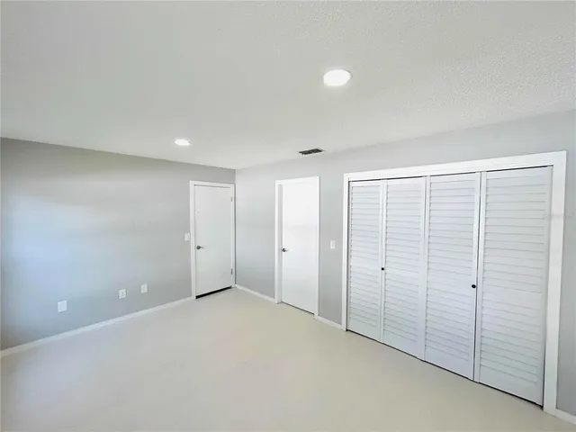 an empty room with windows and closet