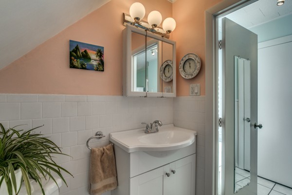 37 Wellman Street, Unit 3 Beverly, MA 01915 - Photo 18 of 21 a bathroom with a sink a mirror and a window