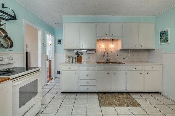 37 Wellman Street, Unit 3 Beverly, MA 01915 - Photo 7 of 21 a kitchen with white cabinets and appliances