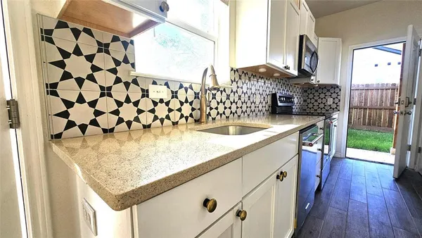 a kitchen with stainless steel appliances granite countertop a refrigerator and a stove