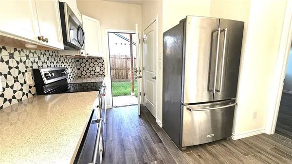 a kitchen with granite countertop a sink stove and refrigerator