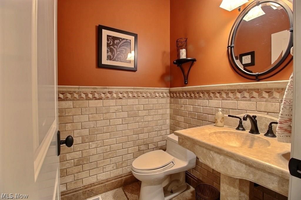 12430 Falcon Ridge Road Chesterland, OH 44026 - Photo 11 of 28 Look at this gorgeous stone detail in this beautiful first floor half bath, travertine floor, solid stone sink and decorative tile walls. Stunning!