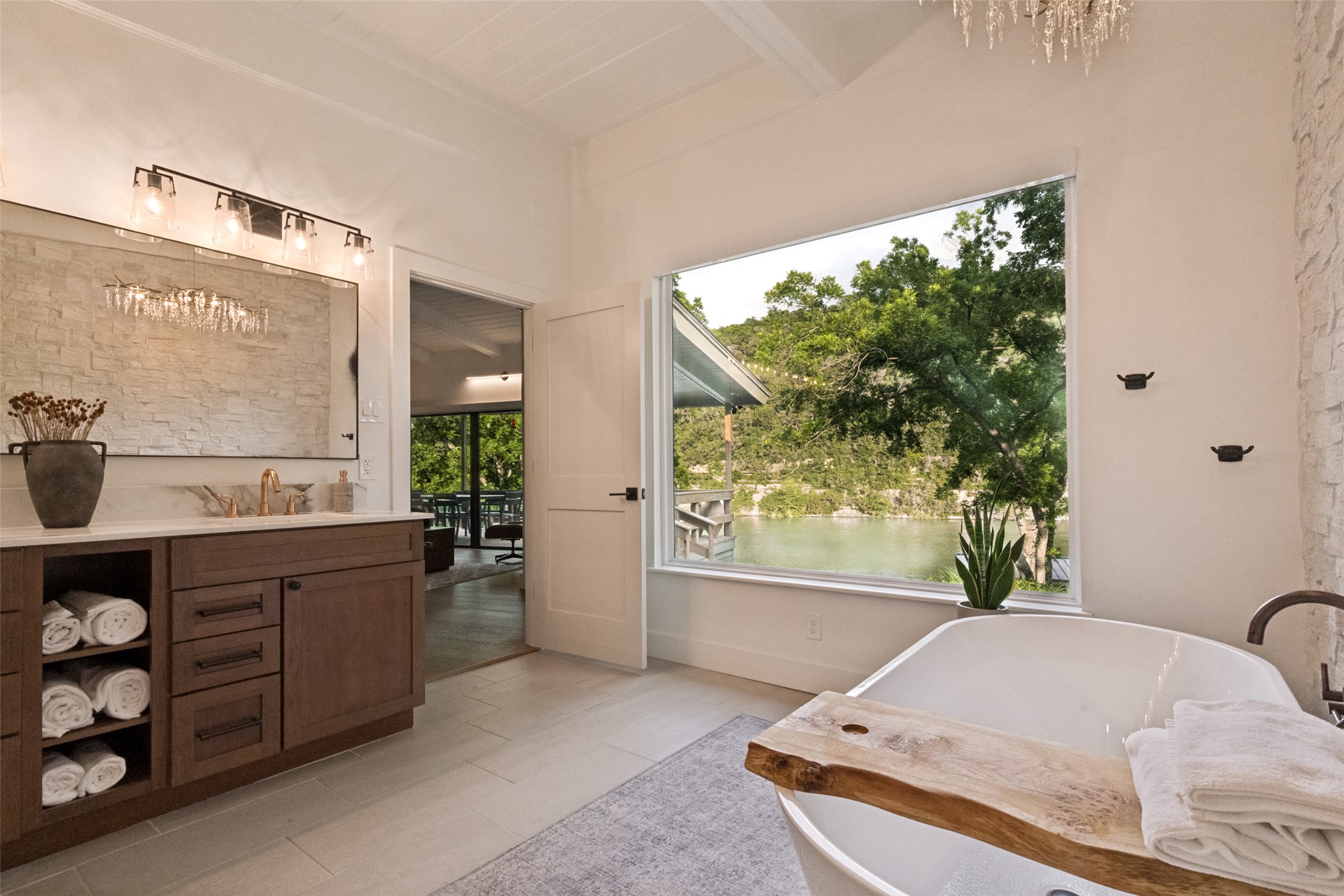 303 Lago Verde Road Austin, TX 78734 - Photo 21 of 39 Indulge in relaxation with this primary bathroom's deep soaking tub overlooking serene lake views.