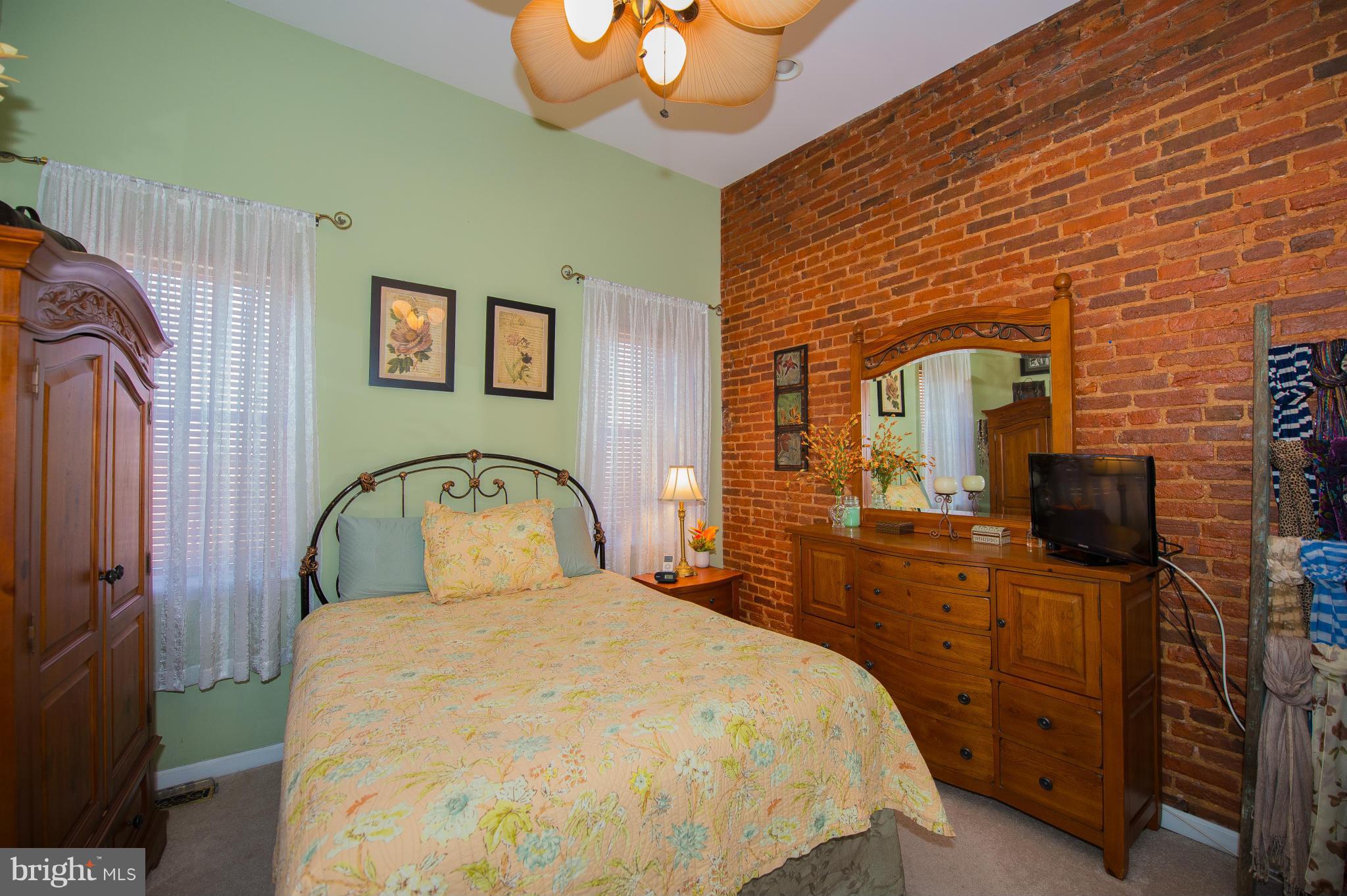 819 South Potomac Street Baltimore, MD 21224 - Photo 16 of 30 a bedroom with a bed and dresser with mirror