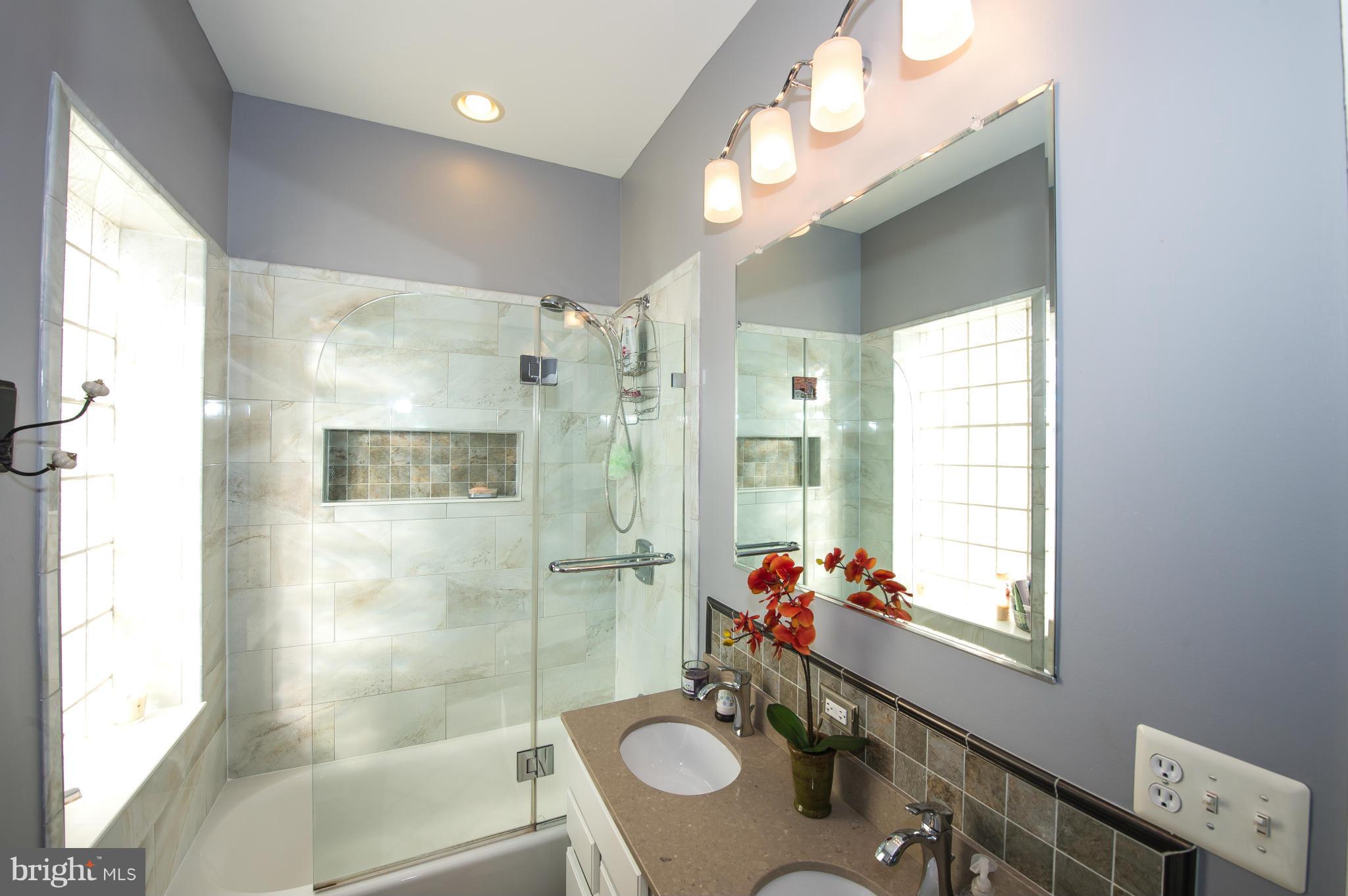 819 South Potomac Street Baltimore, MD 21224 - Photo 21 of 30 a bathroom with a sink a mirror and a shower