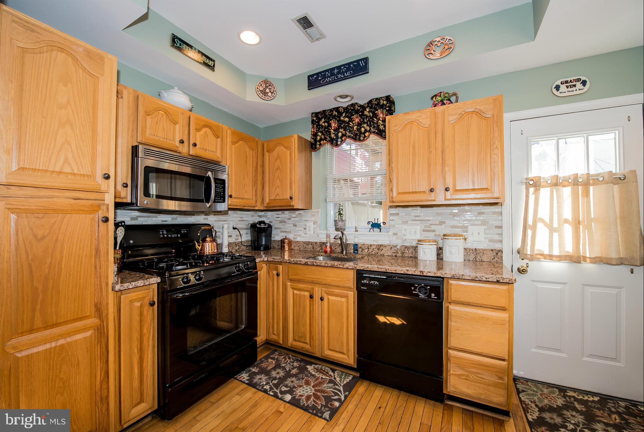 819 South Potomac Street Baltimore, MD 21224 - Photo 8 of 30 a kitchen with stainless steel appliances granite countertop a stove a sink and a microwave