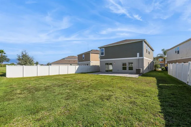 a house view with a big yard plants and large trees