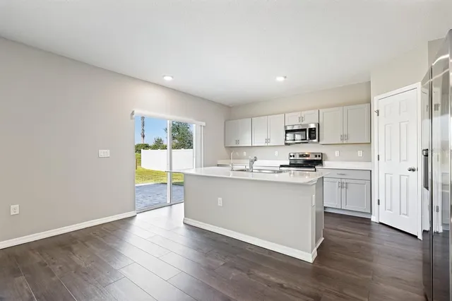 a kitchen with a refrigerator and white cabinets