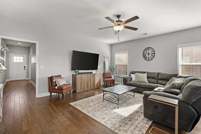 a view of a dining room and livingroom with furniture wooden floor a chandelier