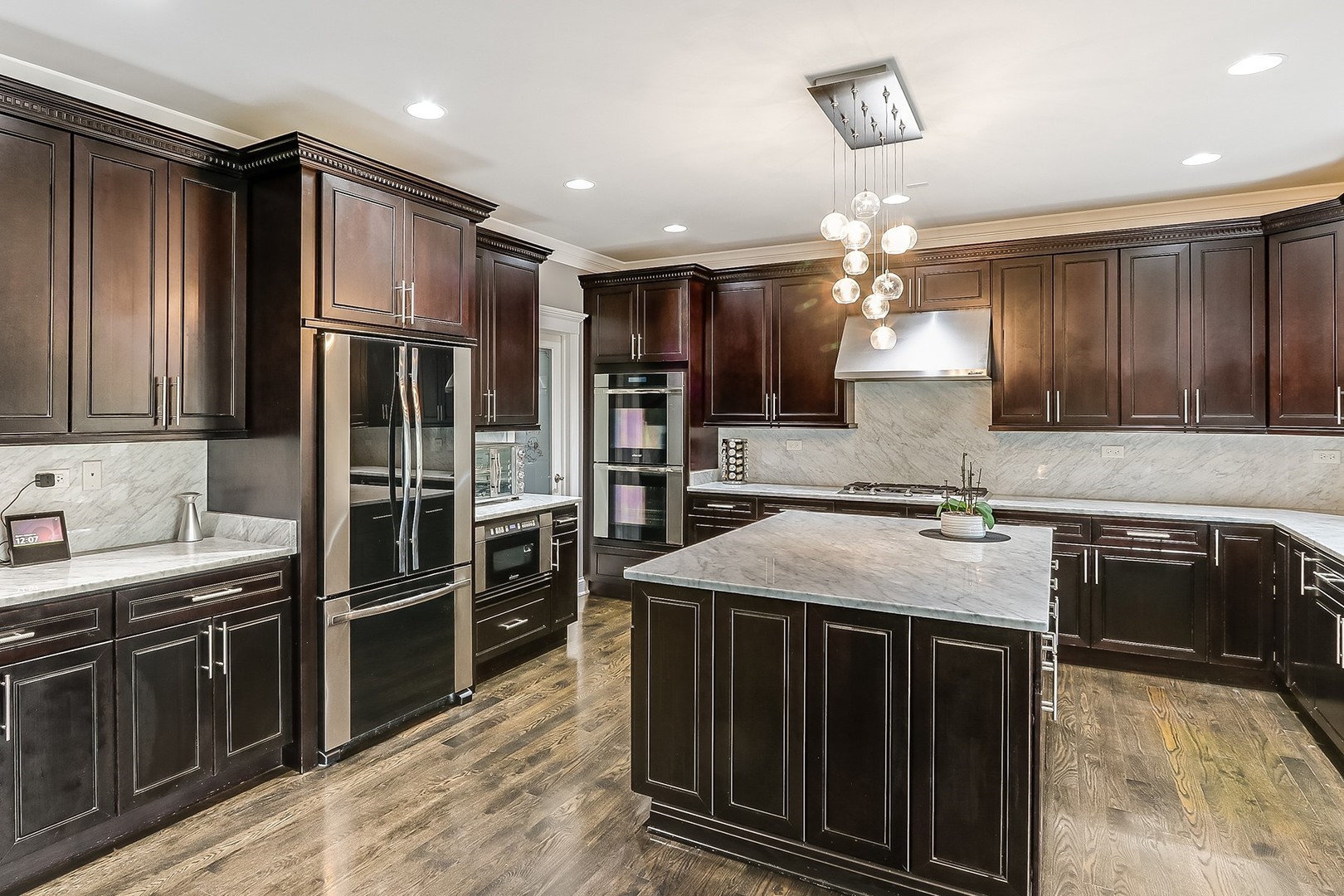 1839 Rizzi Lane Bartlett, IL 60103 - Photo 16 of 50 a kitchen with kitchen island granite countertop stainless steel appliances and wooden cabinets