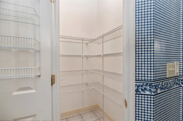 an empty room with a fan & a window