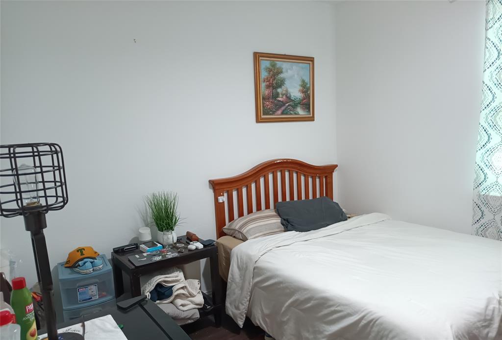 505 Virginia Way Princeton, TX 75407 - Photo 12 of 22 a bedroom with a bed a painting on the wall and a potted plant