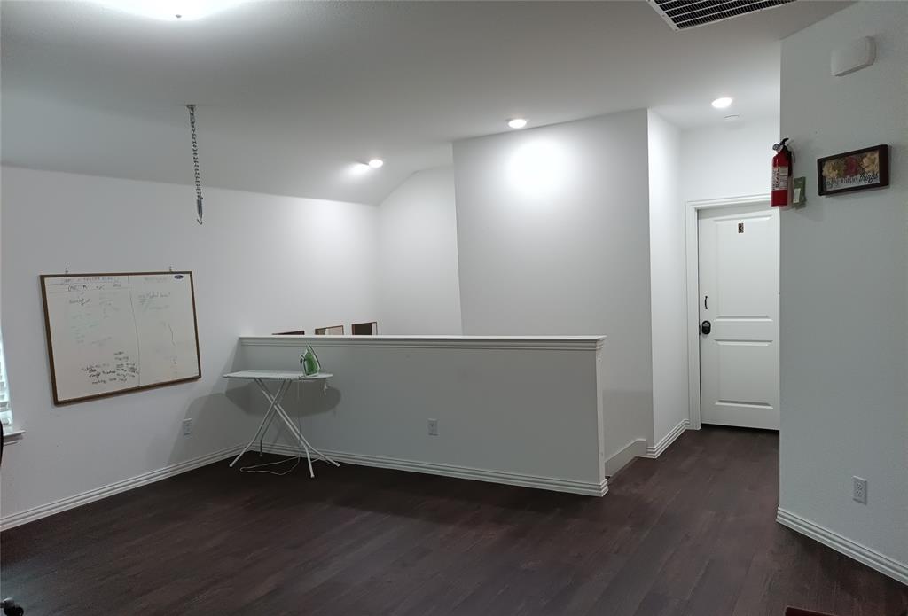 505 Virginia Way Princeton, TX 75407 - Photo 15 of 22 an empty room with wooden floor and cabinet
