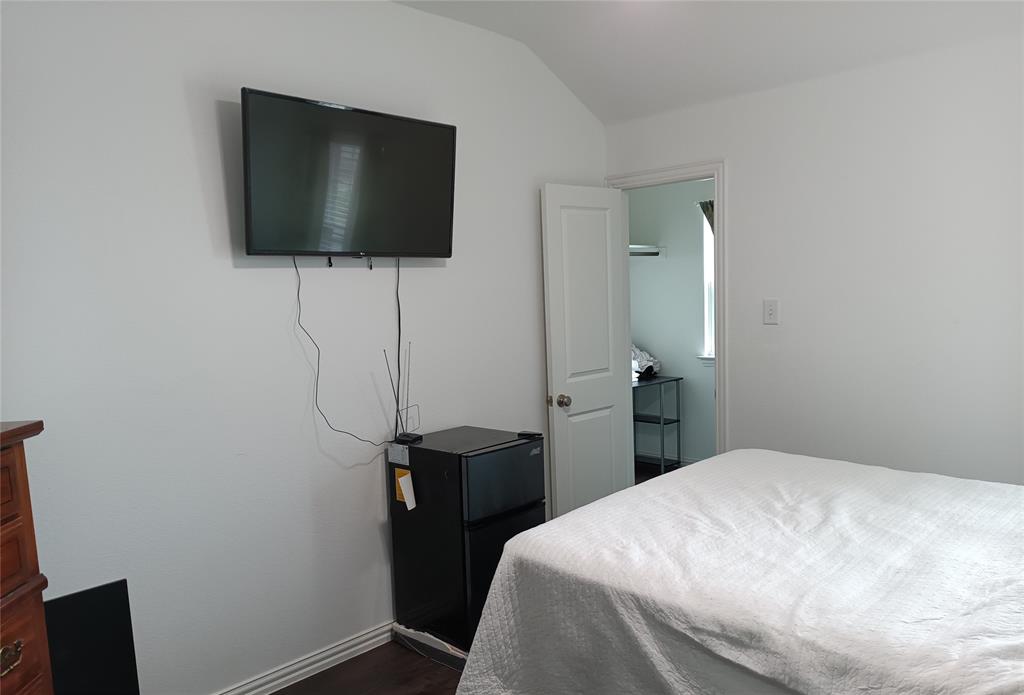 505 Virginia Way Princeton, TX 75407 - Photo 19 of 22 a bedroom with a bed and a flat screen tv