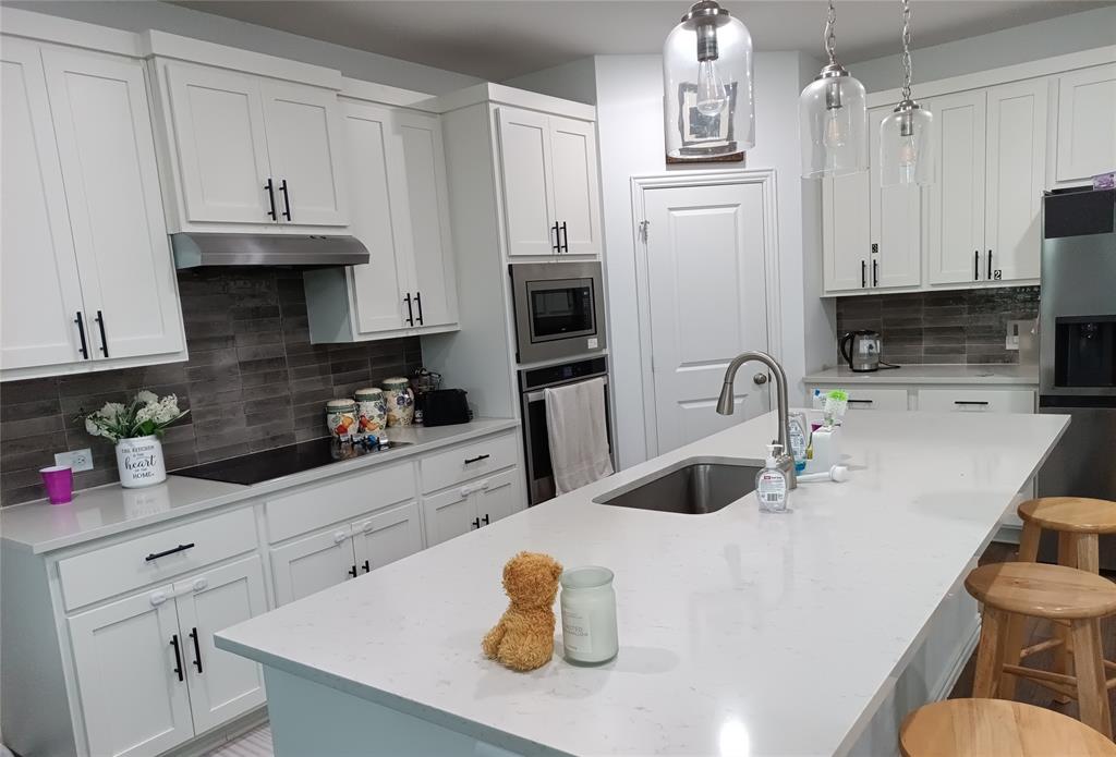 505 Virginia Way Princeton, TX 75407 - Photo 4 of 22 a kitchen with stainless steel appliances a sink a stove a refrigerator and cabinets