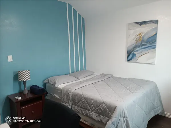 a bedroom with a bed and a painting on the wall