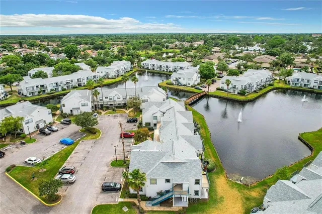 an aerial view of a city with lots of residential buildings ocean and mountain view in back