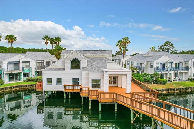 a view of a white house with a yard table and chairs