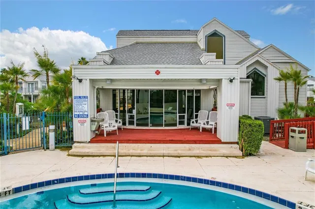 a view of a white house with a swimming pool and a yard