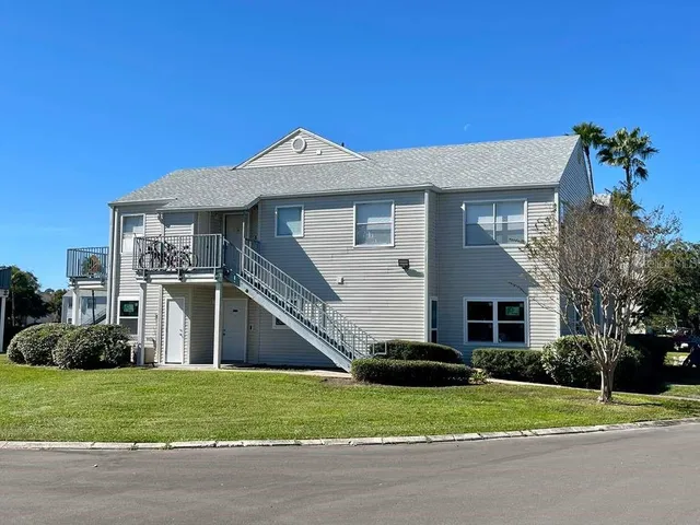 a front view of a house with a yard and trees