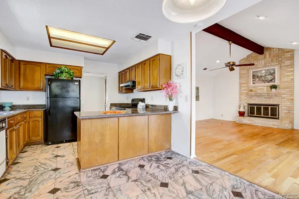 a kitchen with stainless steel appliances kitchen island granite countertop a refrigerator and a stove top oven